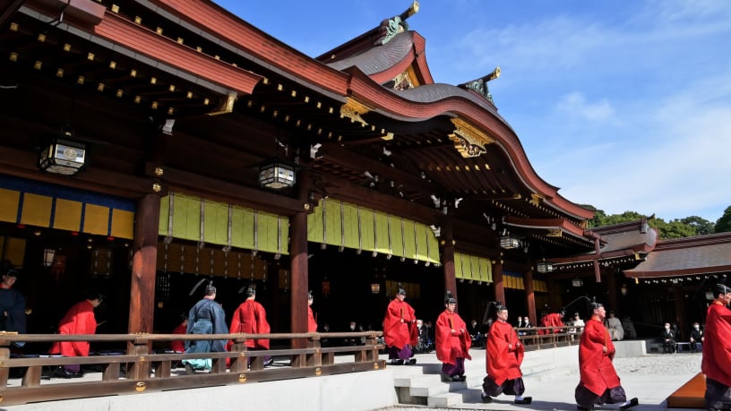 赤い装束の人々が並ぶ神社の拝殿